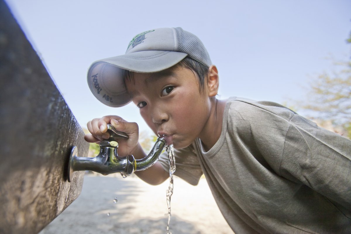 Kid drinking from water faucet