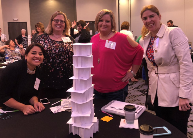 Image of teachers with an index card tower that they created.