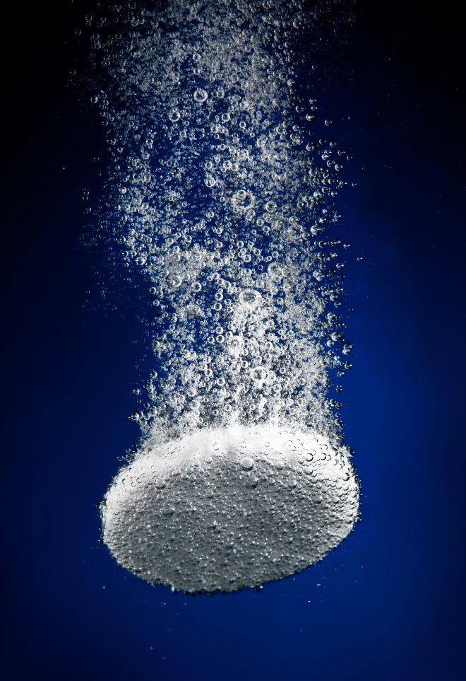 An antacid bubbling as it is disolved in water